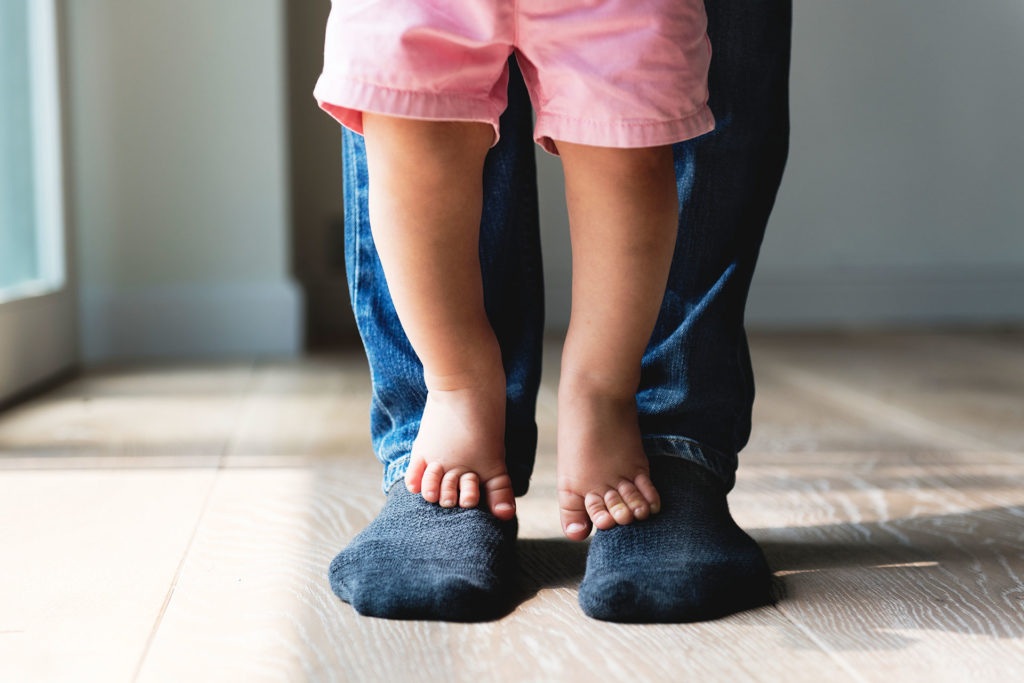 Child standing on father's feet