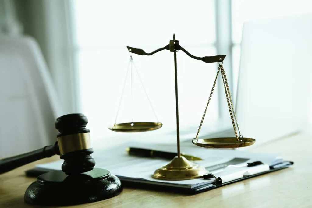 Judge’s gavel and scales of justice on legal documents symbolizing law, fairness, and courtroom decision-making. Judge’s gavel and scales of justice on legal documents symbolizing law, fairness, and courtroom decision-making.