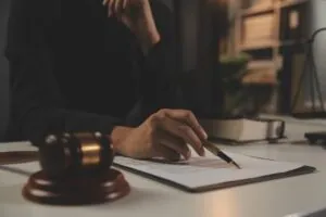 Lawyer writing on a paper and bedside a judge gavel