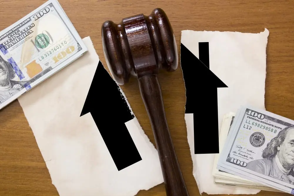 Symbol home torn in half in divorce a legal hammer in the middle.