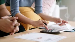 Asian couple stressed over past due bills and debt, facing financial hardship with rising cost of living, low income, loan and tax crisis.