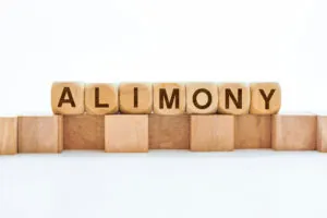 Wooden block with the word ALIMONY representing spousal support in divorce.