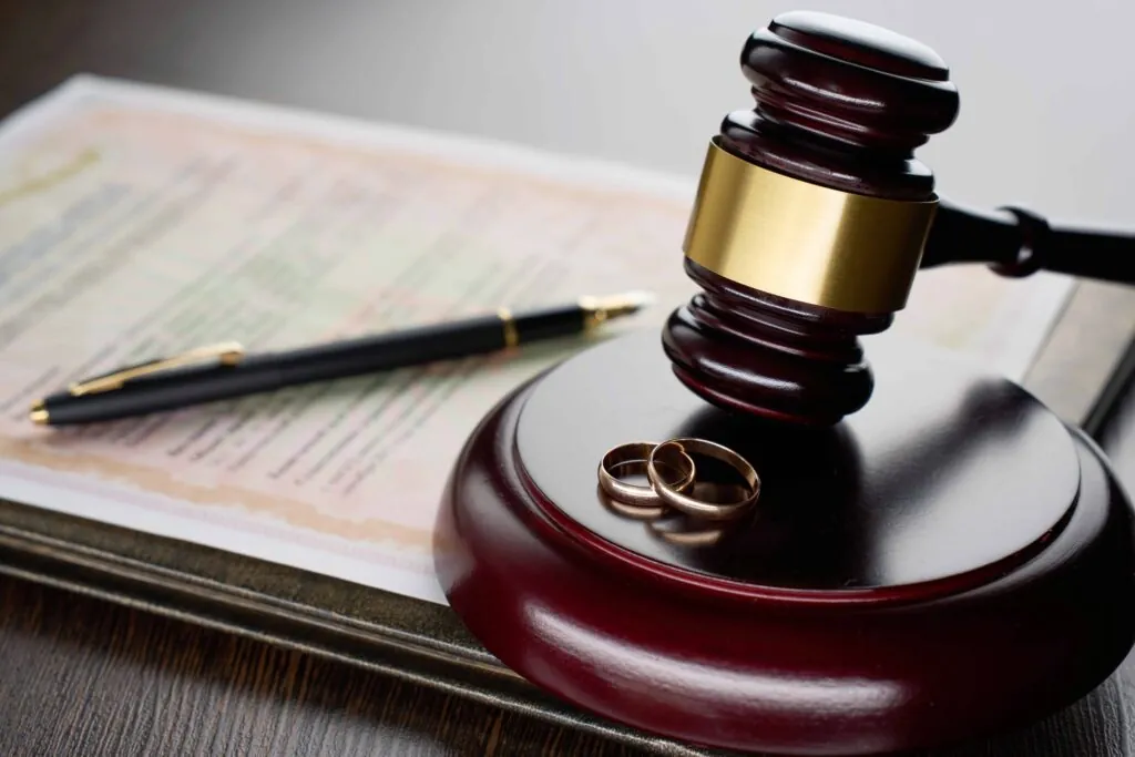 Judge’s gavel with wedding rings and divorce certificate on desk, symbolizing divorce law and legal separation proceedings. Judge’s gavel with wedding rings and divorce certificate on desk, symbolizing divorce law and legal separation proceedings.