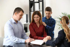Couple with their child signing child custody agreement with legal counsel