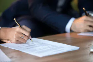 Close-up of couple's hands signing documents